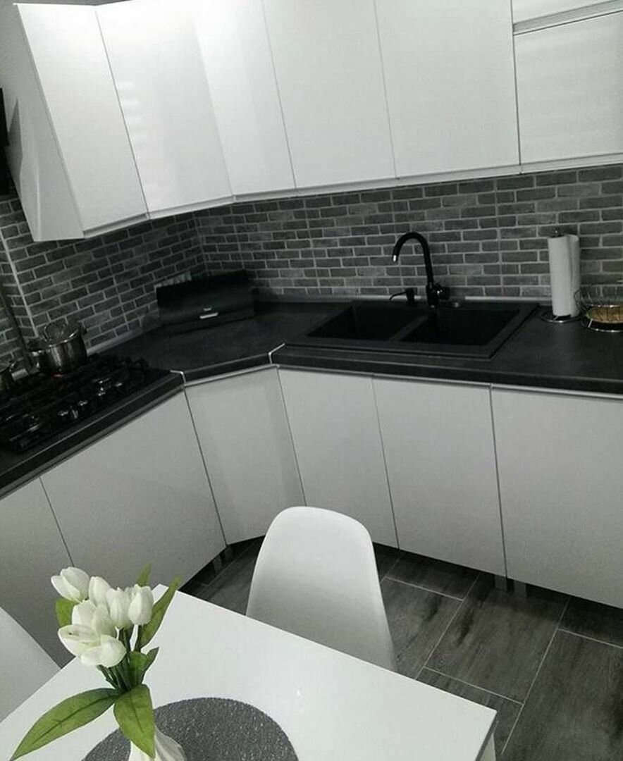 Белая угловая кухня с черной столешницей
