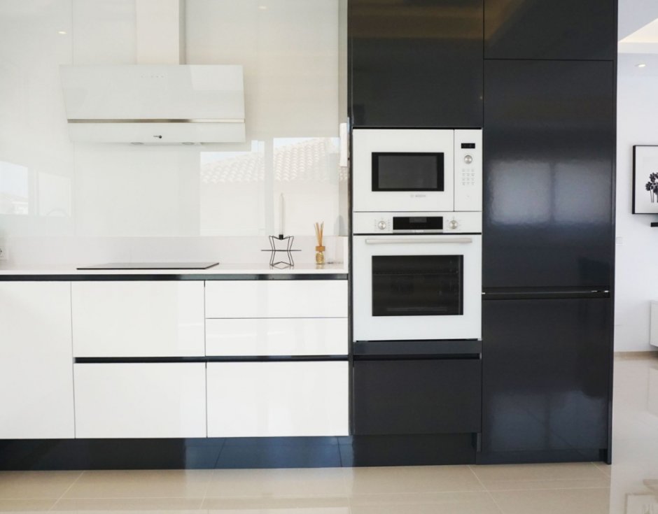 Черный холодильник в интерьере белой кухни