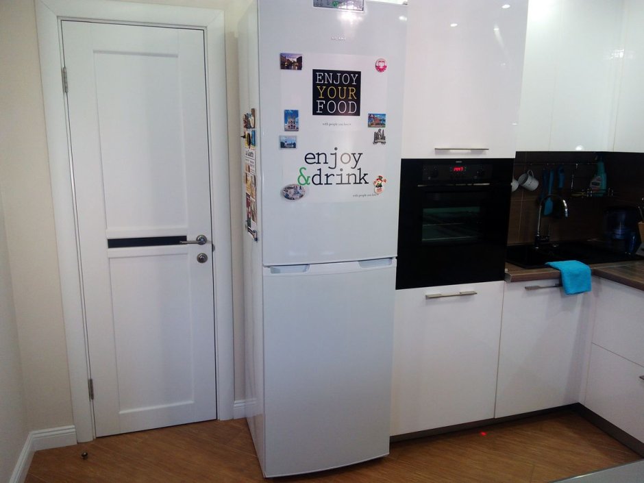 Белая кухня с холодильником в нише