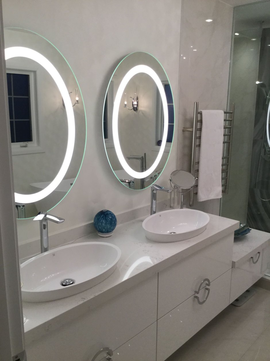 Круглое зеркало над раковиной в ванной