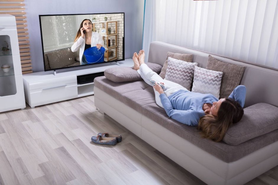 Девушка на диване перед телевизором