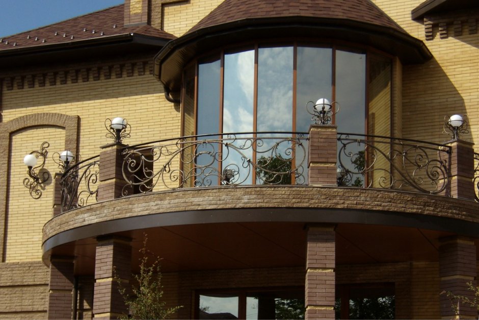 Красивый вид дома с кованым балконом