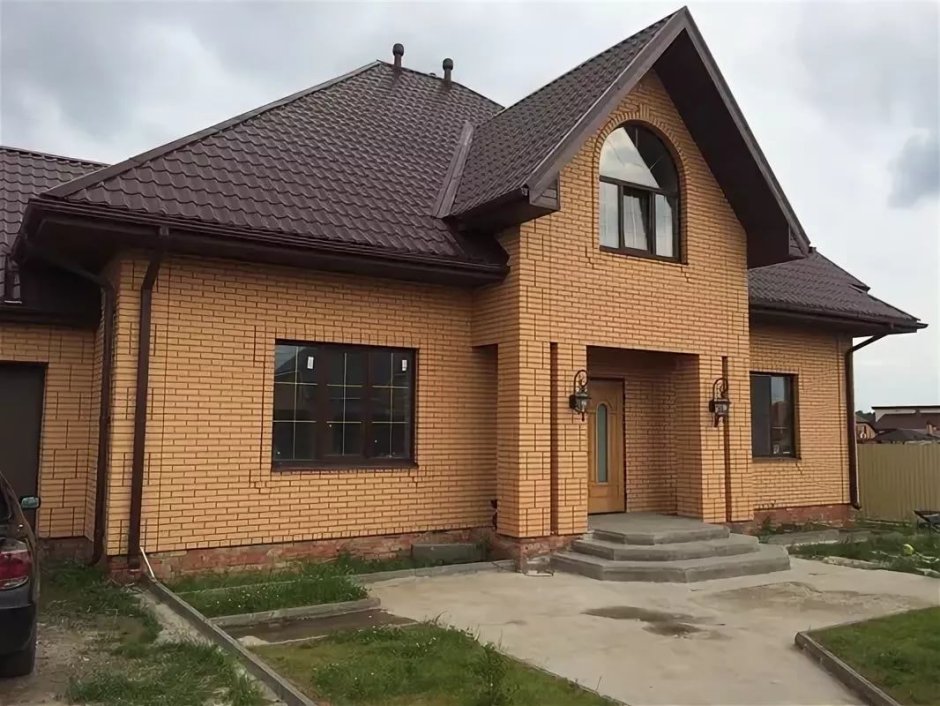 Одноэтажный дом из желтого кирпича с коричневыми