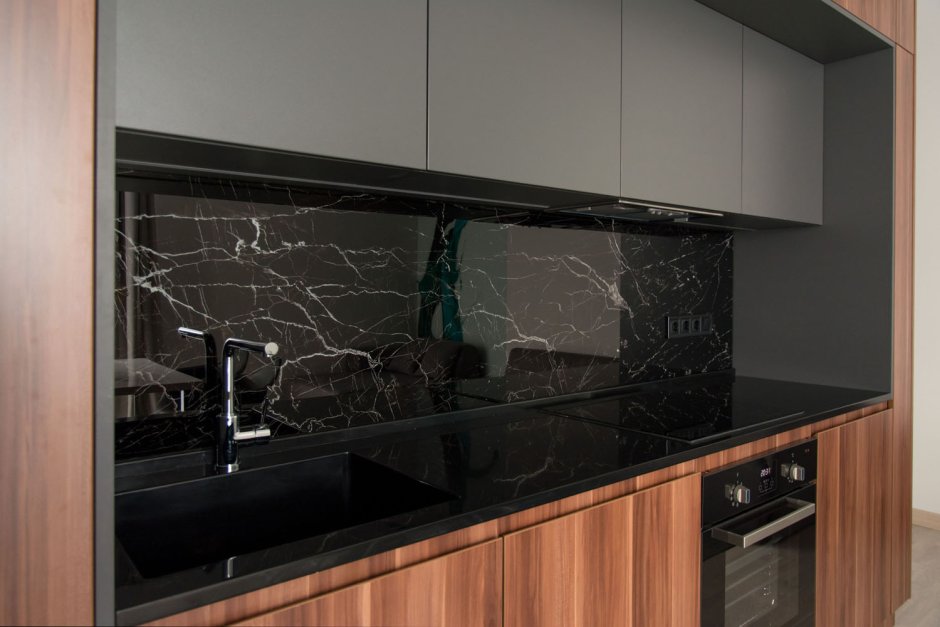 Кухня с черной столешницей и фартуком