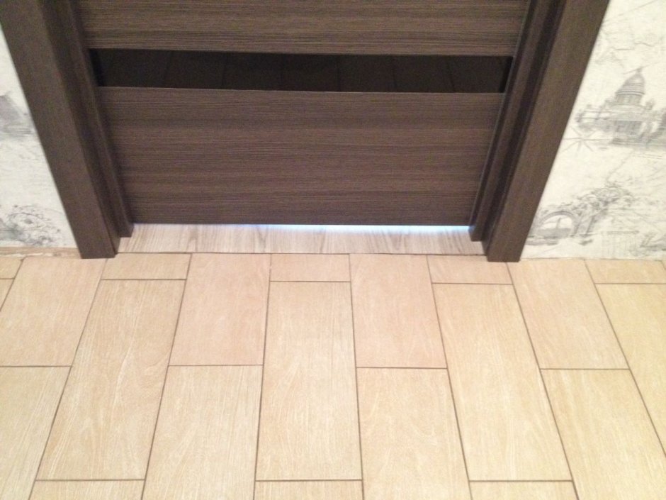 Стык плитки и ламината под дверью