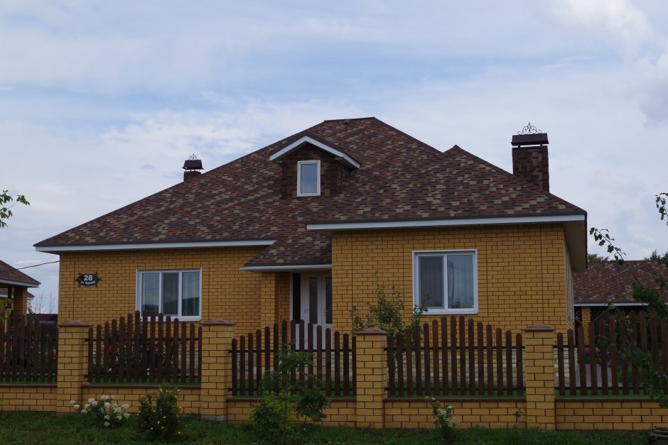 Кирпичный дом с коричневой крышей