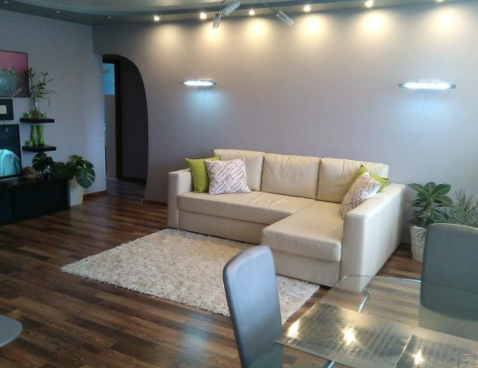 Часы над диваном в интерьере гостиной