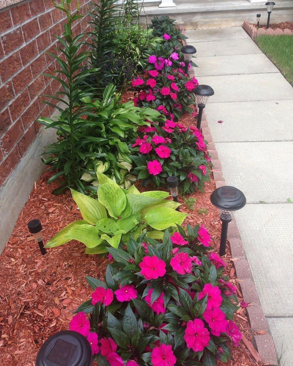 Клумбы из колёс вдоль забора