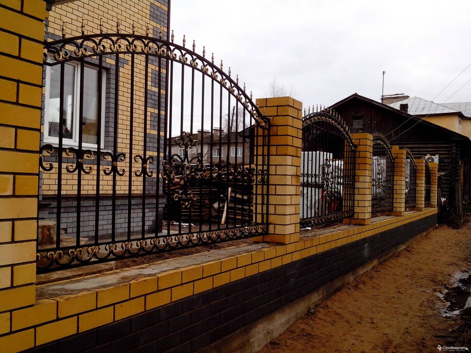 Кованый забор с кирпичными столбами
