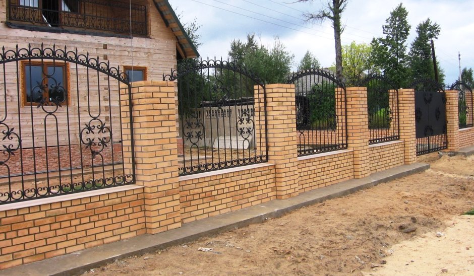 Кованый забор с кирпичными столбами