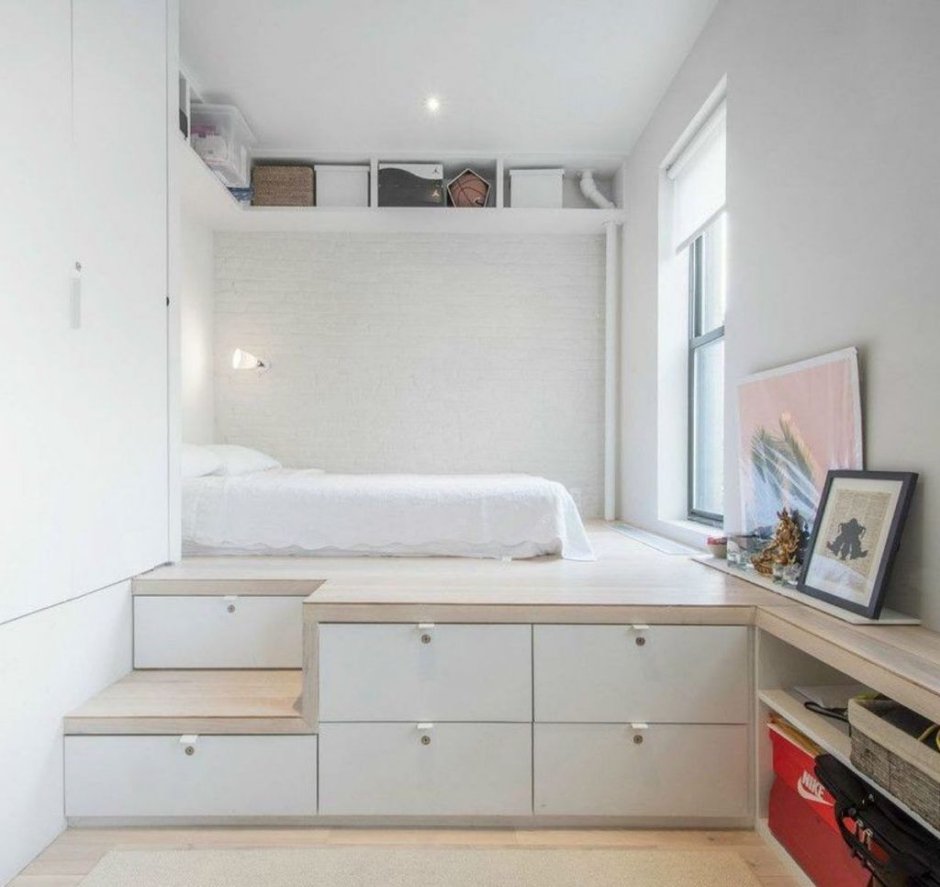 Кровать на подиуме в маленькой комнате со шкафом