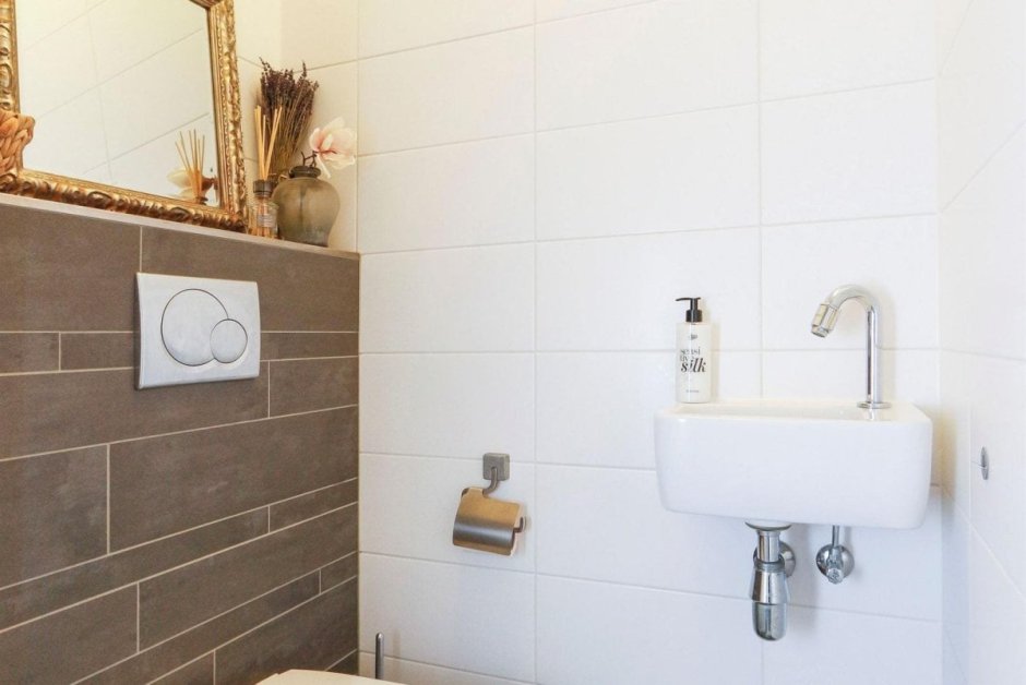 Ванная с белой плиткой и черной затиркой