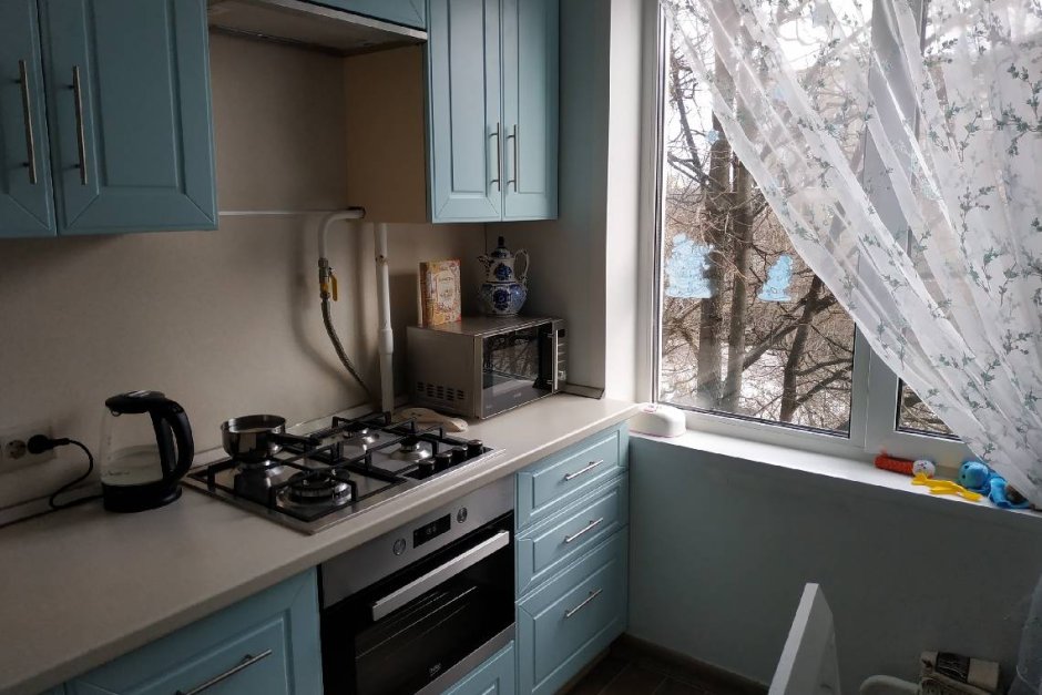 Маленькая кухня с холодильником у окна
