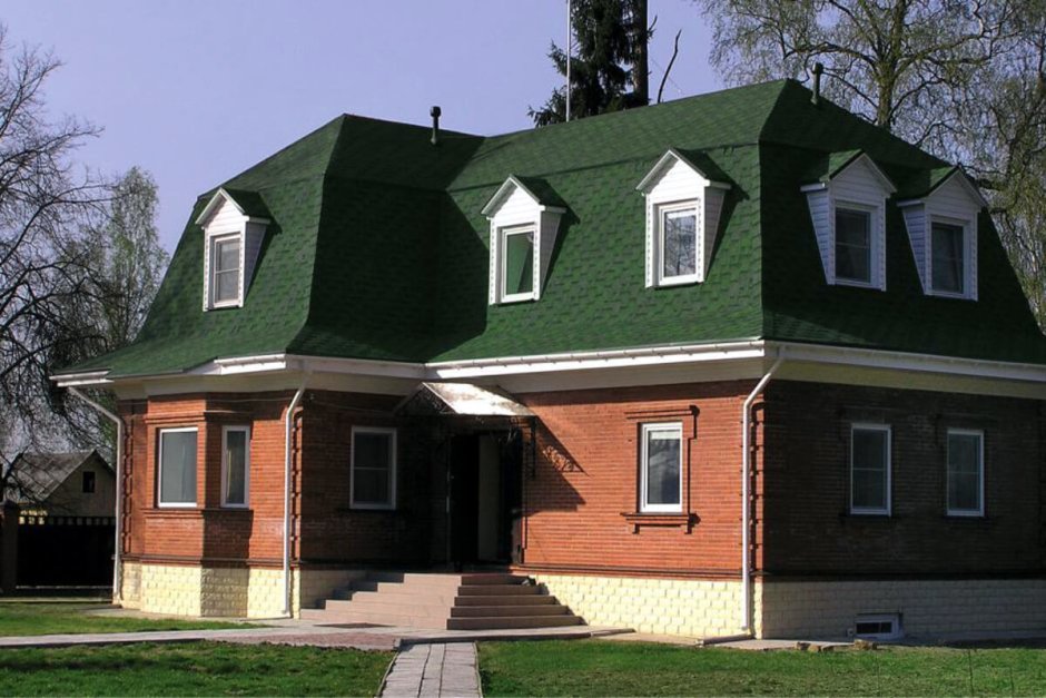 Кирпичный дом с зеленой крышей