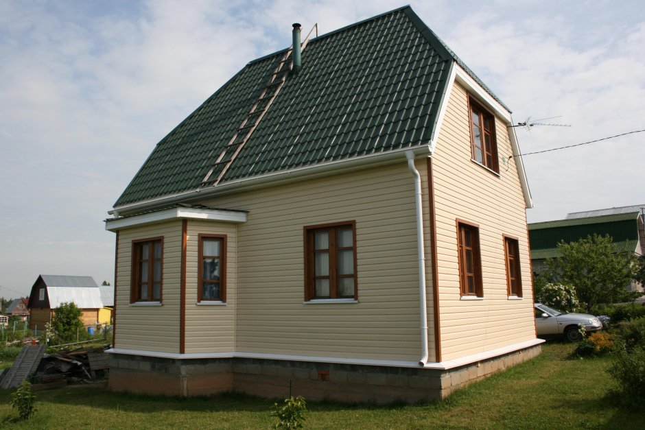 Фасады домов с зеленой крышей