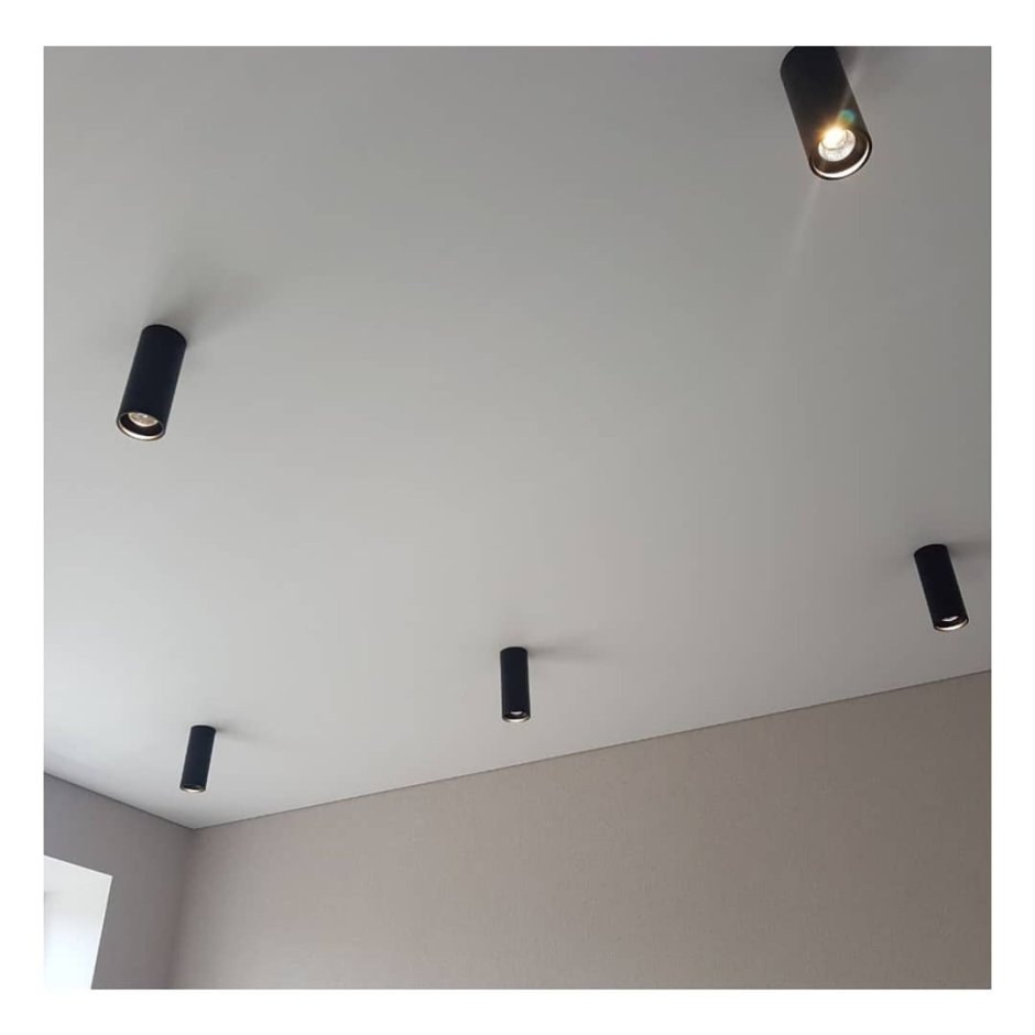 Черные светильники на белом потолке