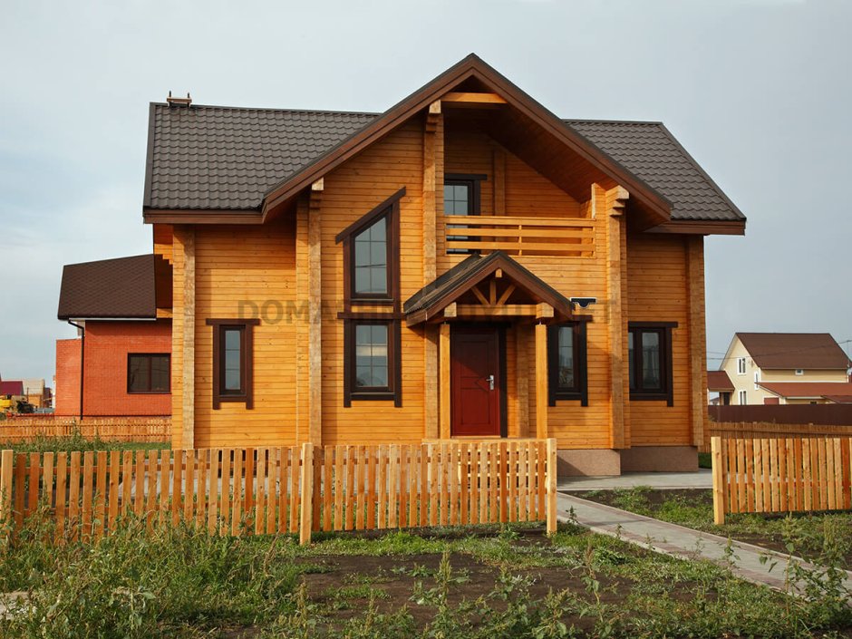 Брусовой дом с коричневой крышей
