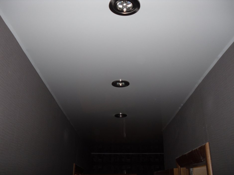 Черные сполерные светильники на глянцевом потолке