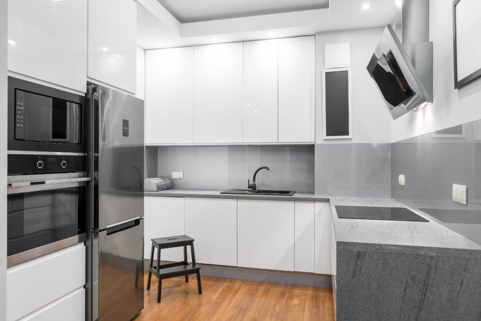 Белая кухня с серебристым холодильником