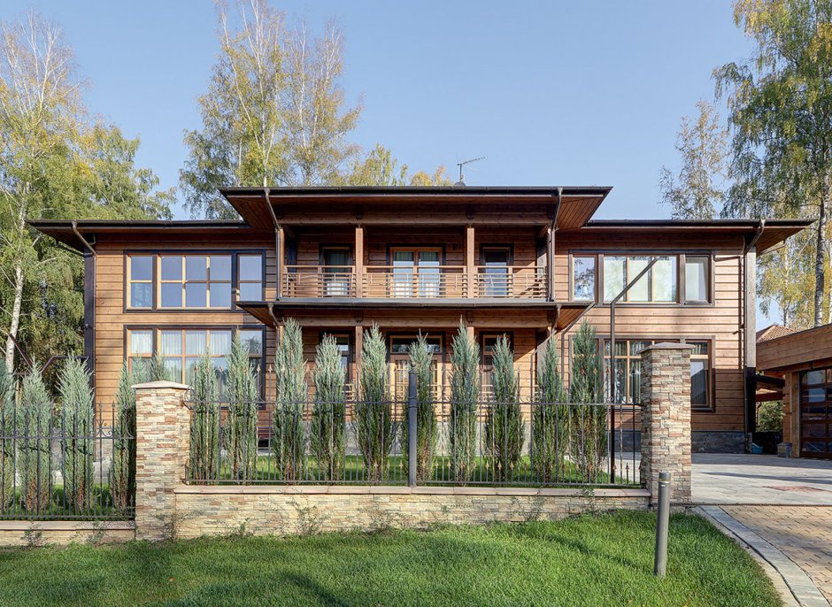 Участок у реки с красивым двухэтажным деревянным домом с балконами