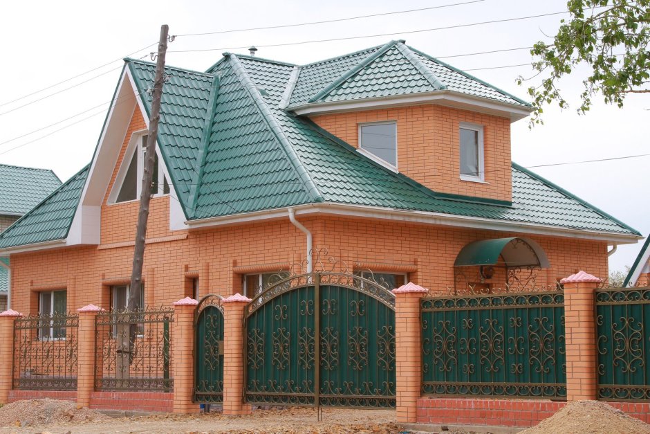 Кирпичный дом с зеленой крышей