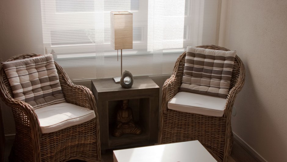 Плетёное кресло и столик из ротанга в интерьере гостиной