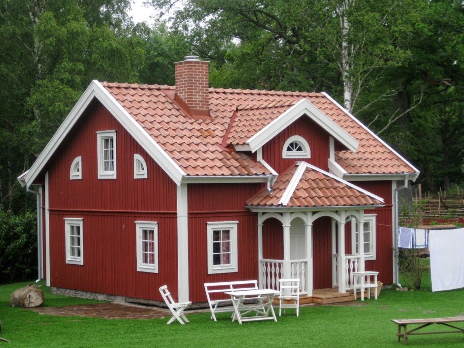 Деревянный дом с красной черепичной крышей